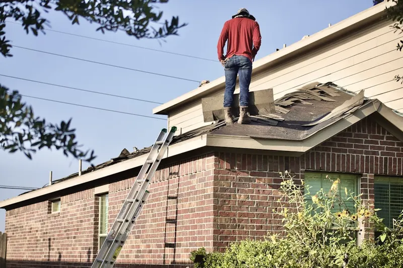 Professional roofer working on a residential roof in East Dennis